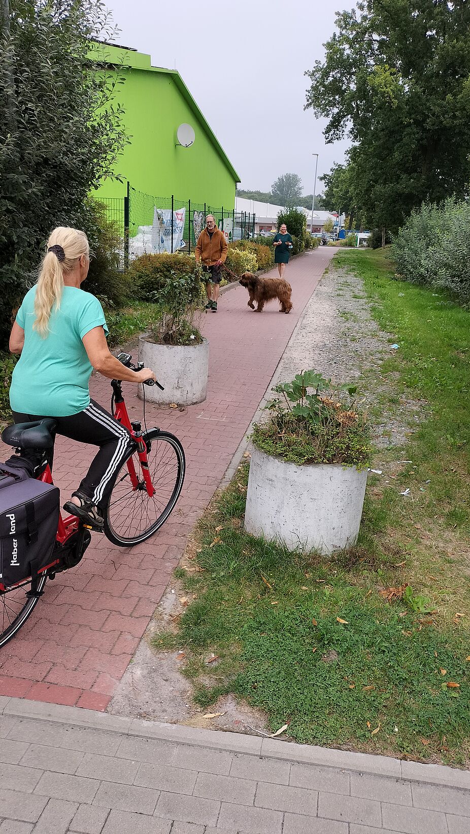 ADFC_Foto_September-22 Radfahrerin passiert Weg mit Betonkübeln